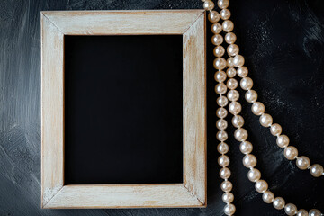 A beautifully crafted wooden frame sits next to a strand of shiny pearls on a rich dark background, evoking a sense of elegance