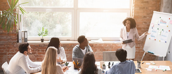 Wall Mural - Black lady employee making presentation during morning briefing in office