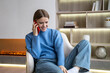 © DimaBerlin - Contented woman making phone calls gossips with friend enjoys relaxed time on weekend. Happy female talking with smartphone flirting distant with boyfriend at home. Pleasant mobile conversation.