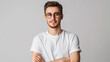 © Mahemud - Daylight portrait of young handsome Caucasian man isolated on grey background, dressed in white t-shirt and round eyeglasses, looking at camera and smiling positively