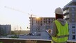 © volha_r - Construction female engineer taking notes and writing on clipboard while inspecting a building site