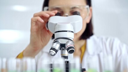 Woman scientist using microscope in laboratory. Microbiology science concept