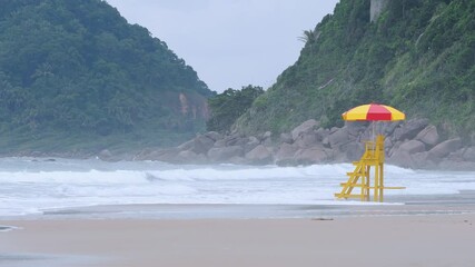 Wall Mural - Rough sea at the Tombo beach of Guaruja - SP, Brazil. Beach of the coast of São Paulo state. View to the beach, the lifeguard chair and some mountains on background.