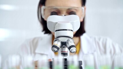 Woman scientist using microscope in laboratory. Microbiology science concept