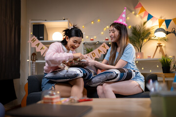 Two Asian women in room with Ciematic lighting celebrate important events such birthdays Christmas