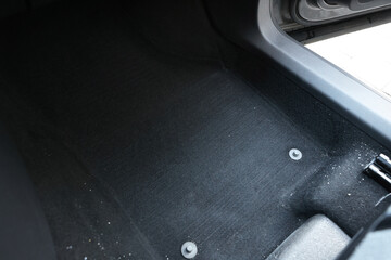 Black soft car floor mat in auto, closeup