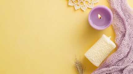 Flat lay with a burning candle, knitted scarf, and doily on a yellow background.