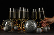 © Atlas - Glasses of champagne with Christmas balls on a black background