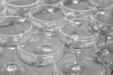 A lot of empty wine glasses. Row of clean glass transparent glasses are on a table on banquet in a bar.