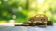 © Cyber Shutter - Pile of coins alongside a paper car on a blurred green background representing the concept of vehicle purchasing and sales