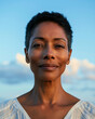 © tiagozr - Black woman smiling gently outdoors.