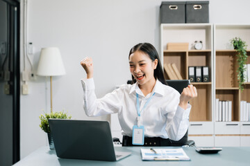 Young Asian businesswoman working with working notepad, tablet and laptop documents talking