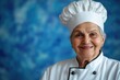 © Vii - A happy woman wearing a chef's hat smiles directly at the camera