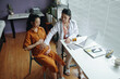 © DragonImages - Doctor in white coat sitting in clinic discussing with pregnant woman holding her belly, surrounded by medical equipment and office supplies on desk