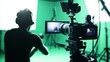 © Aris Suwanmalee - A filmmaker captures footage in a green screen studio, showcasing modern video production techniques and creative setup.