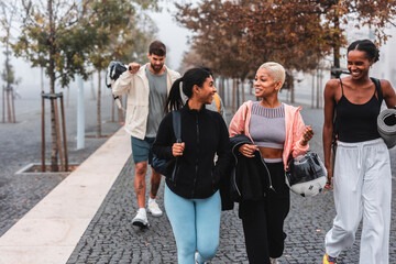 Group of sporty friends walking together in the city after training