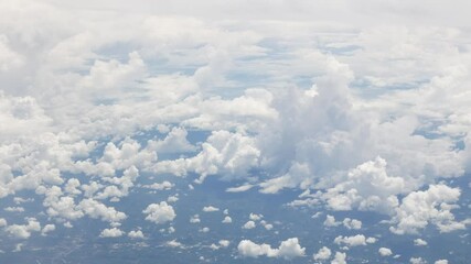 Wall Mural - view from plane over blue sky with white Fluffy clouds while flying through in sunny summer time.nature blue sky cloud and sun for Clean Environment, save energy or transportation holiday concept. 
