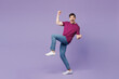 © ViDi Studio - Full body young man wears violet t-shirt casual clothes doing winner gesture celebrate clenching fists say yes raise up leg isolated on plain pastel light purple background studio. Lifestyle concept.