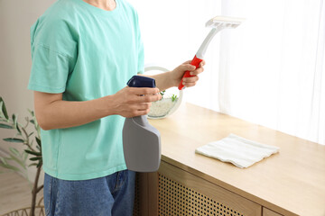 Woman with squeegee and detergent at home