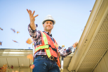 Wall Mural - man with hard hat standing on steps inspecting house roof