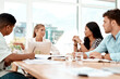 © peopleimages.com - Woman, business people and office meeting with discussion, ideas or listen with smile at startup company. Group, team and happy with paperwork for review, brainstorming or feedback at creative agency