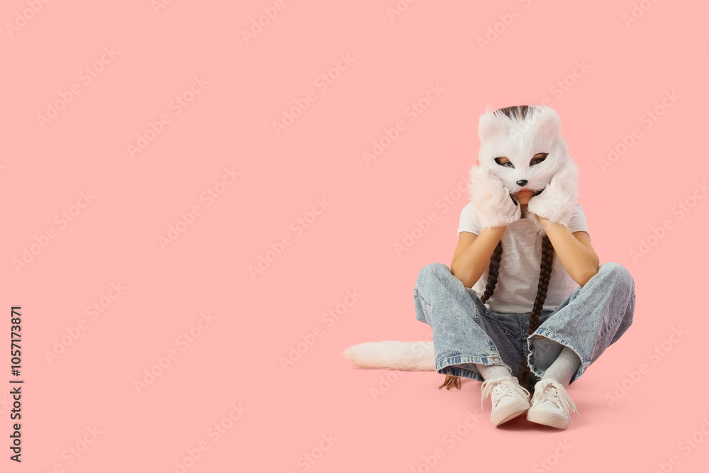 Quadrober girl in cat mask sitting on pink background