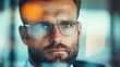 © JoxyAimages - A focused man wearing glasses examines the world quietly through a clear glass barrier, embodying concentration, thoughtfulness, and intellectual curiosity.