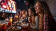 © Tamara - Friends enjoying food and drinks at sports bar.
