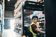 © Davor - Warehouse worker operating forklift in storage aisle