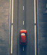 © Di Studio - aerial view of modern red car driving on straight asphalt city road with copy space