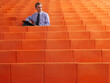 © Designpics - Businessman Sitting in Auditorium