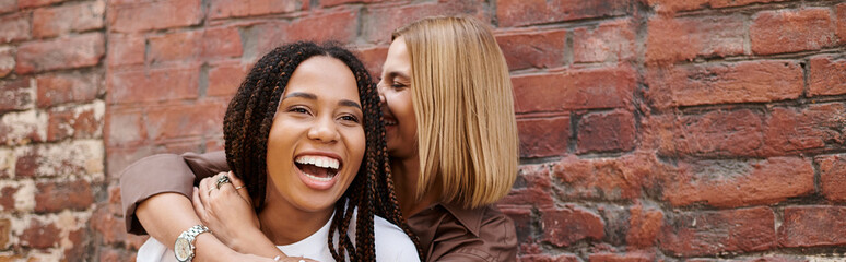 A smiling African American woman enjoys a delightful moment with her girlfriend, sharing laughter