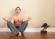 © Designpics - Man Sitting on Floor with Bonsai Tree