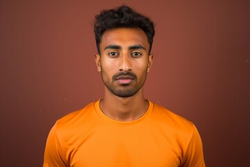 Canvas Print - Portrait of a content indian man in his 20s sporting a breathable mesh jersey in front of blank studio backdrop