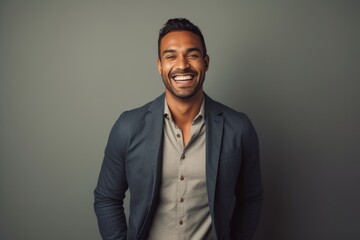 Wall Mural - Portrait of a joyful indian man in his 30s wearing a chic cardigan isolated on light wood minimalistic setup