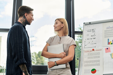 Two coworkers engage in a focused discussion about their project in a modern workspace.