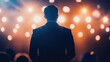 © Bijac - motivational speaker captivates the audience from the stage, silhouetted against bright lights, inspiring hope and ambition during a dynamic business event