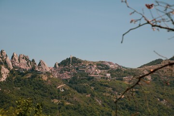 Poster - Scenic view of an old town on top of a green hill on a sunny day