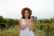 © prochkailo - A Young Woman Holding a Camera Captured Beautifully in a Scenic Natural Landscape