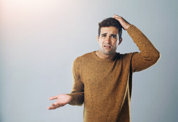 Aufkleber - How did that happen. Studio shot of a handsome young man scratching his head in confusion against a gray background.