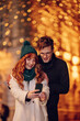 © Zamrznuti tonovi - Festive couple taking selfies on a city street at new year's eve.