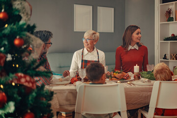 Wall Mural - Happy family enjoying christmas dinner together at home