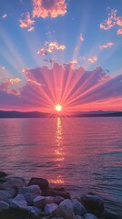 Wall Mural - Beautiful sunset with colorful rays over a serene lake surrounded by mountains