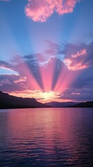 Wall Mural - Beautiful sunset with colorful rays over a serene lake surrounded by mountains