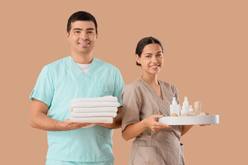 Poster - Massage therapists with spa supplies on beige background