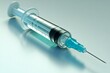 © Leo Rohmann - Syringe with transparent liquid in close up against light blue background representing healthcare vaccination and medical equipment with emphasis on sterilization