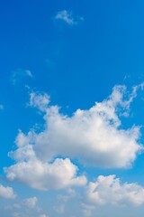 this captivating stock image features a wide blue sky filled with fluffy white clouds. the serene at
