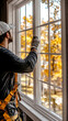 © pabscal - A professional energy efficiency technician working on a window of a house.