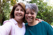 © Wavebreak Media - Senior female friends smiling together outdoors, enjoying festive holiday moment