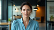 © Keopaserth - confident woman in modern office setting, wearing light blue shirt, exudes professionalism and focus. contemporary workspace features stylish furniture and bright atmosphere, enhancing her poised